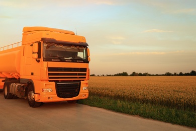 Photo of Modern yellow truck on country road. Space for text