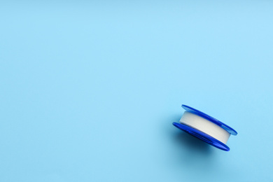 Sticking plaster roll on light blue background, top view. Space for text