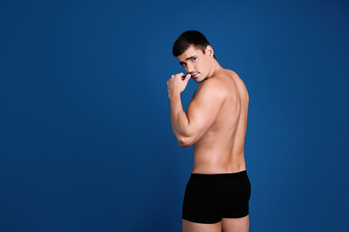 Photo of Man with sexy body on blue background. Space for text