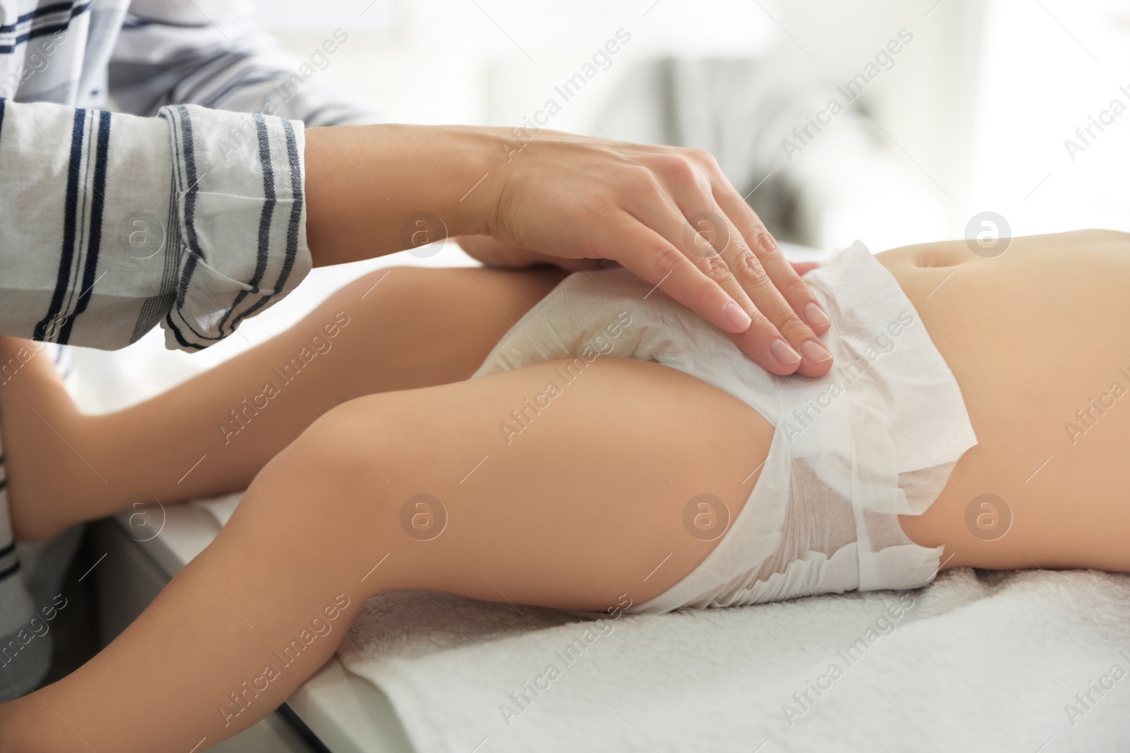 Photo of Mother changing baby's diaper on table at home, closeup