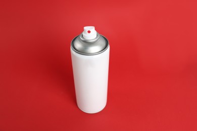Photo of White can of spray paint on red background