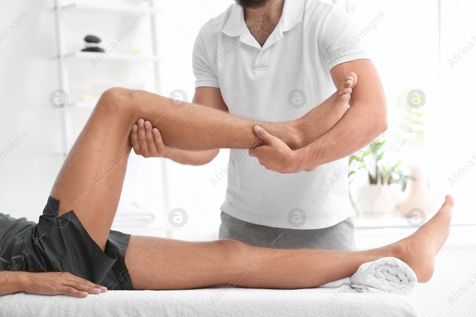 Photo of Young man receiving massage in salon, closeup