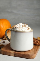 Cup with tasty pumpkin spice latte on light table