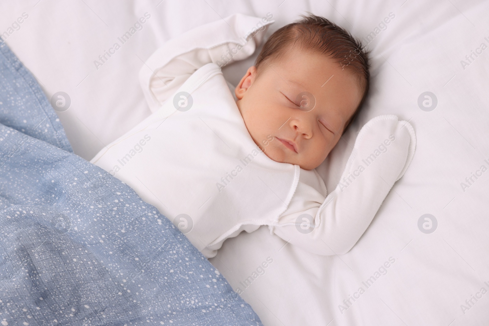 Photo of Cute newborn baby sleeping under blue blanket on bed, top view