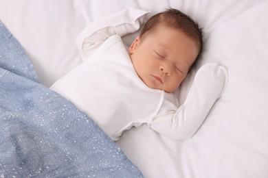 Cute newborn baby sleeping under blue blanket on bed, top view