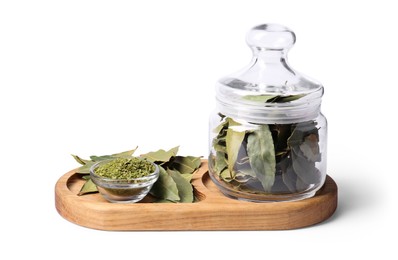 Whole and ground aromatic bay leaves on white background