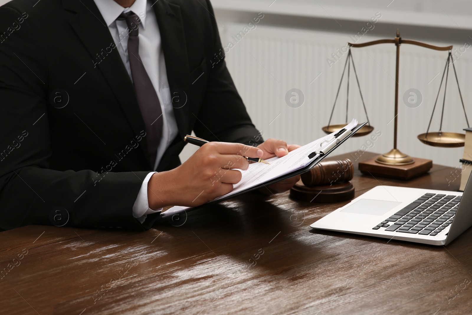 Photo of Law and justice. Lawyer working with documents at wooden table, closeup