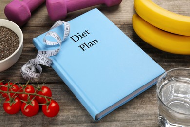 Photo of Weight loss concept. Notebook, fitness items and different products on wooden table