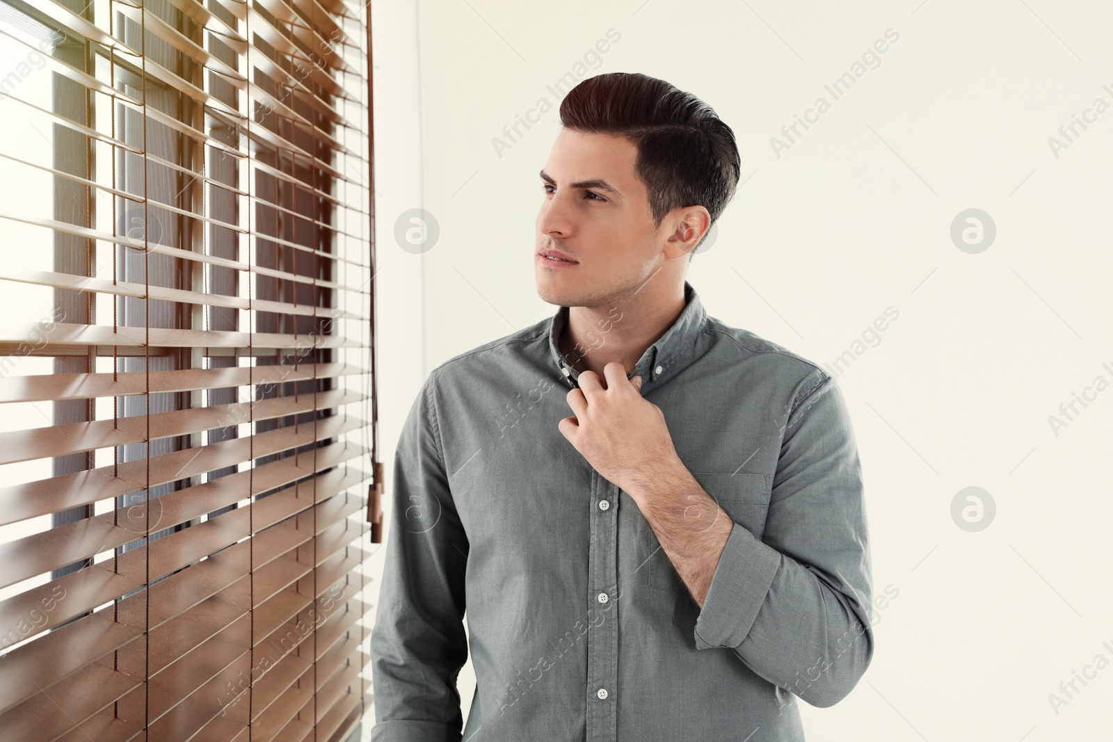 Photo of Portrait of handsome man at window indoors