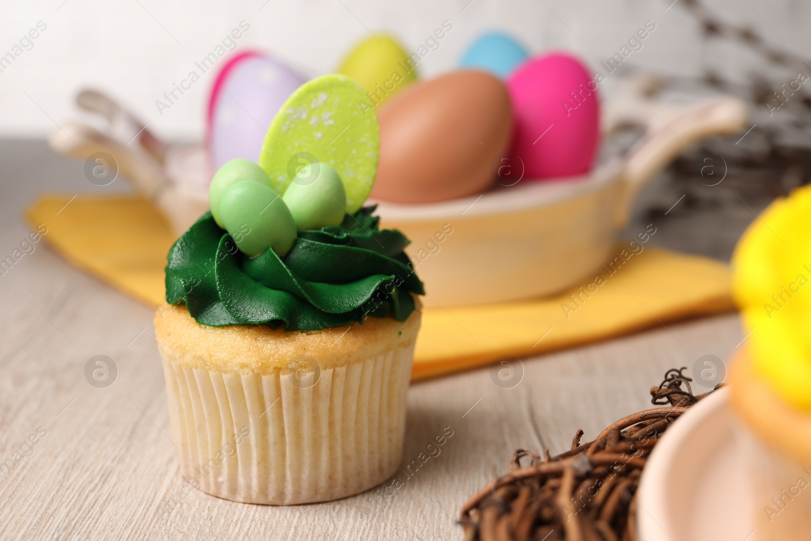 Photo of Tasty cupcake with Easter decor on wooden table, closeup