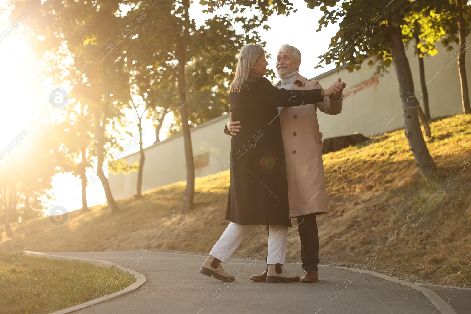 Photo of Affectionate senior couple dancing together outdoors. Romantic date