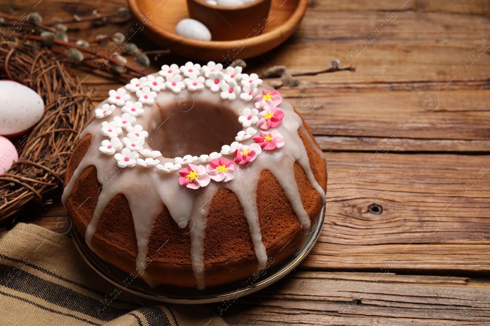 Photo of Delicious Easter cake decorated with sprinkles on wooden table. Space for text