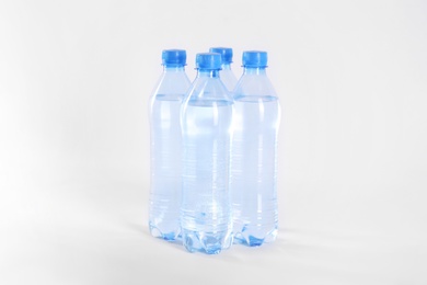 Photo of Plastic bottles with pure water on white background