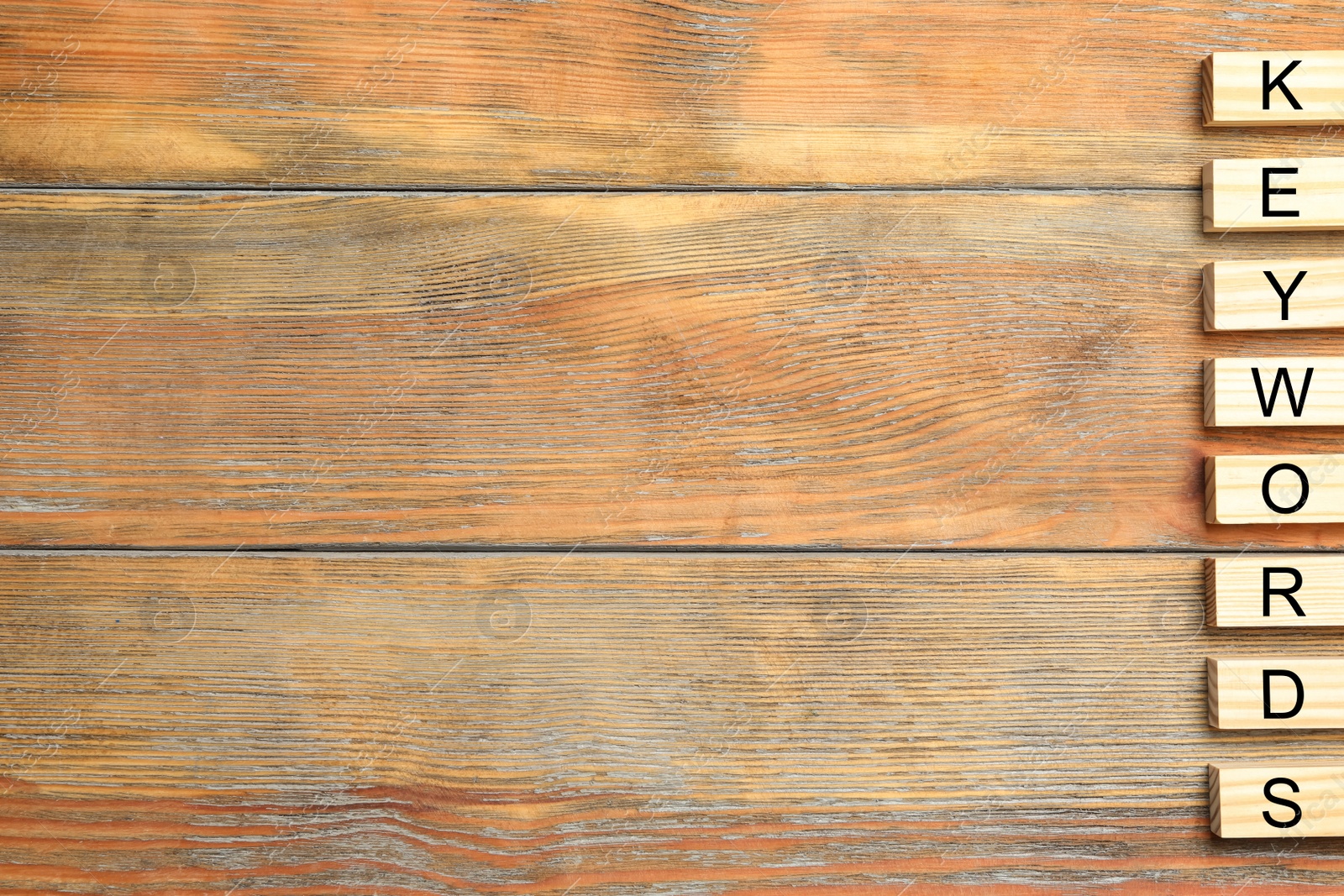 Photo of Blocks with word KEYWORDS on wooden table, flat lay. Space for text