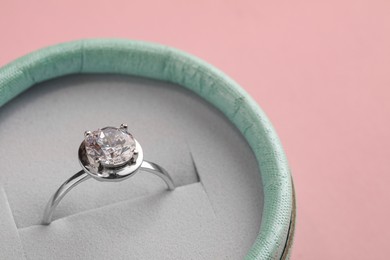 Photo of Beautiful box with engagement ring on pink background, closeup