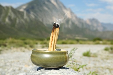 Photo of Burning palo santo stick in high mountains