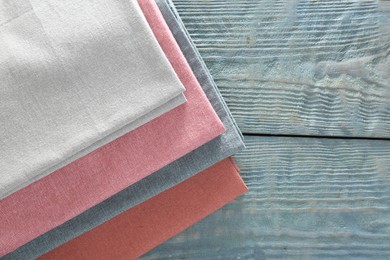 Photo of Different colorful napkins on wooden table, top view. Space for text