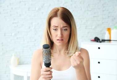 Young woman with hair loss problem at home