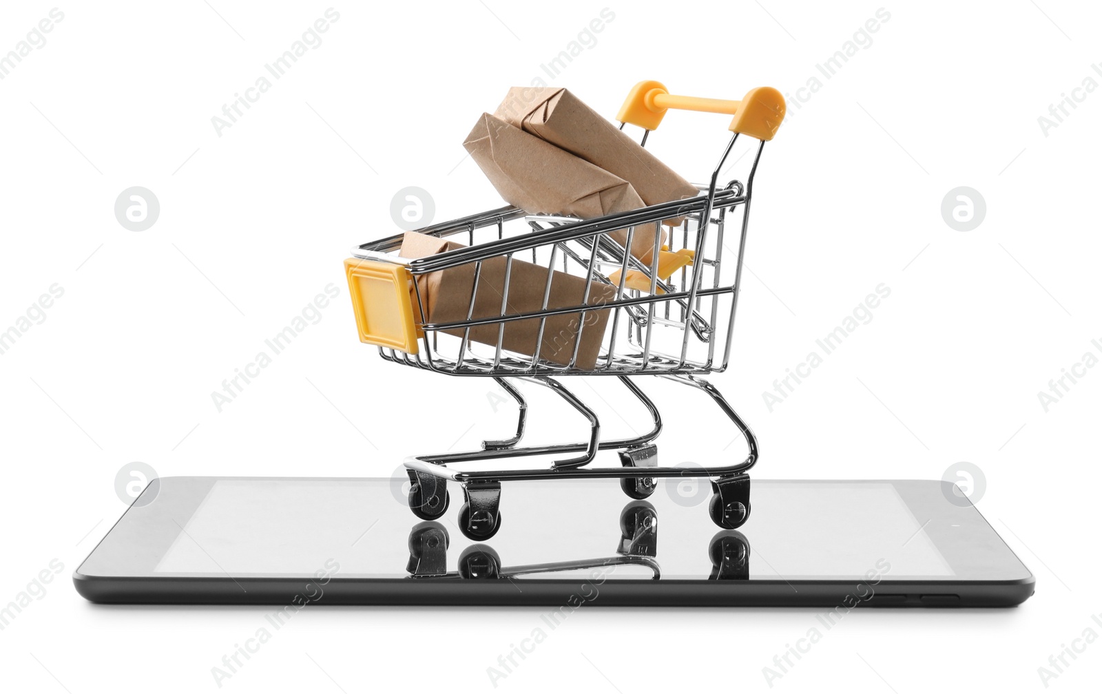 Photo of Internet shopping. Small cart with boxes and modern tablet on white background