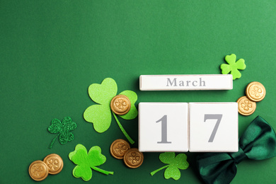 Photo of Flat lay composition with wooden block calendar on green background, space for text. St. Patrick's Day celebration