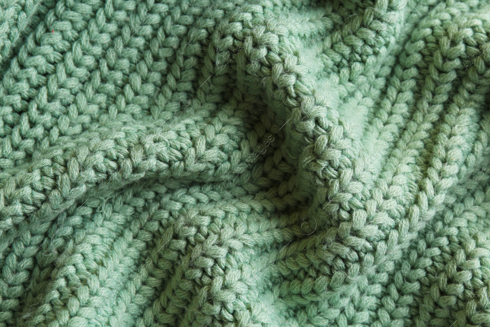 Photo of Beautiful pale green knitted fabric as background, top view