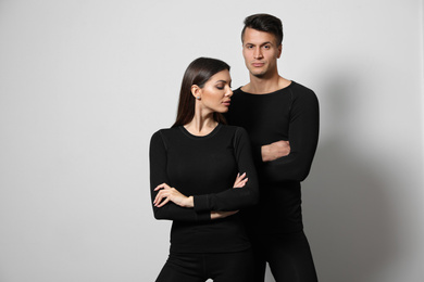 Photo of Couple wearing thermal underwear on light grey background