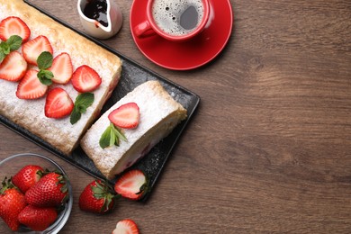 Photo of Delicious cake roll with strawberries and cream served on wooden table, flat lay. Space for text