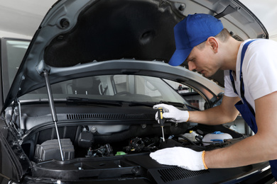 Photo of Professional auto mechanic fixing modern car in service center