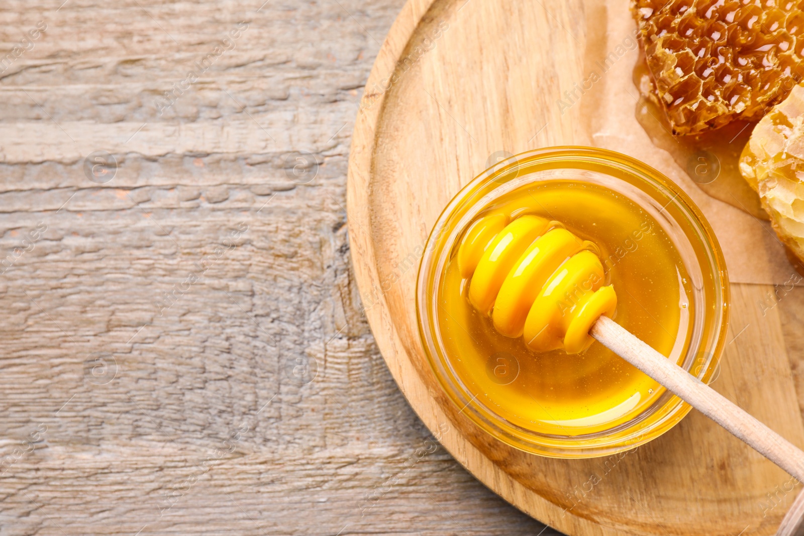 Photo of Tasty aromatic honey on wooden table, flat lay. Space for text