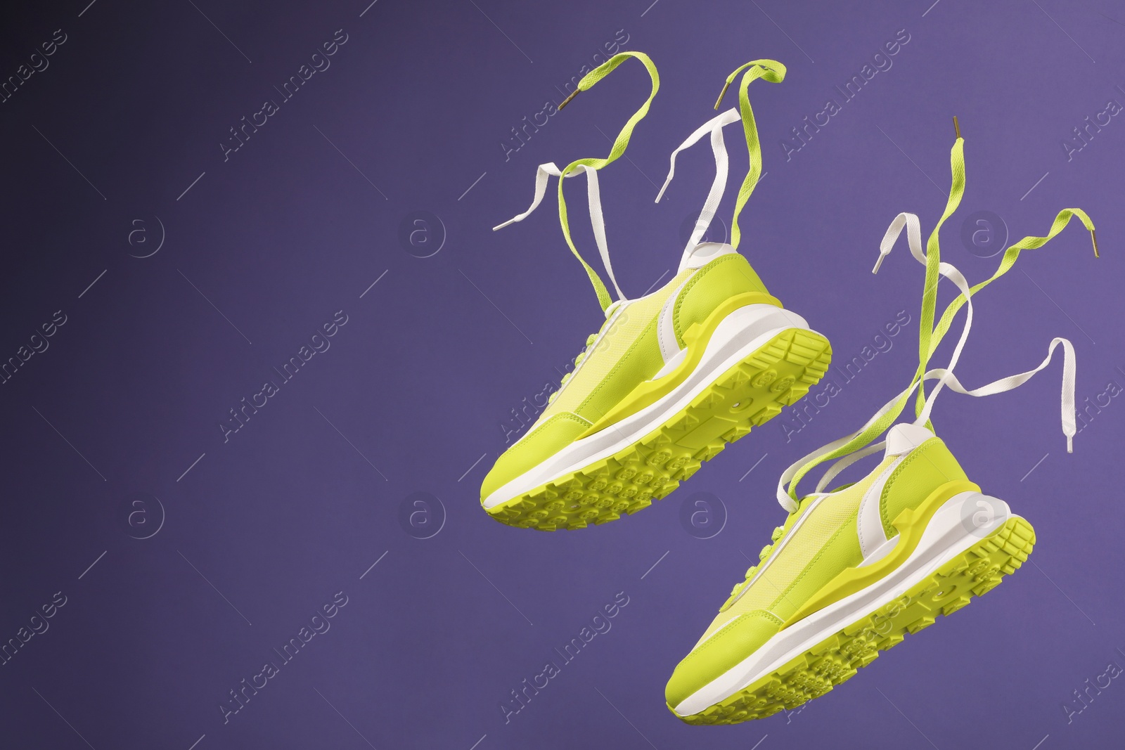 Photo of Pair of stylish sneakers on purple background. Space for text