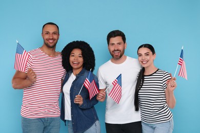 4th of July - Independence Day of USA. Happy friends with American flags on light blue background