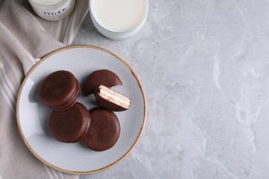 Photo of Tasty choco pies and milk on light grey marble table, flat lay. Space for text