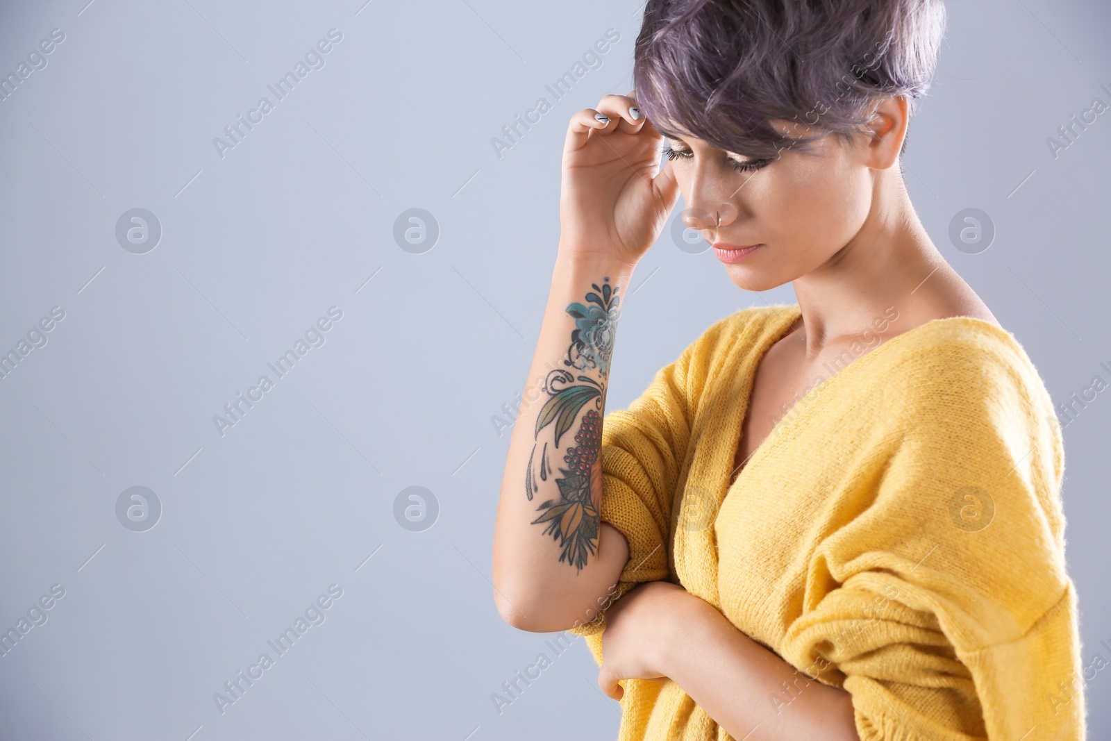 Photo of Young woman with tattoo on color background. Space for text