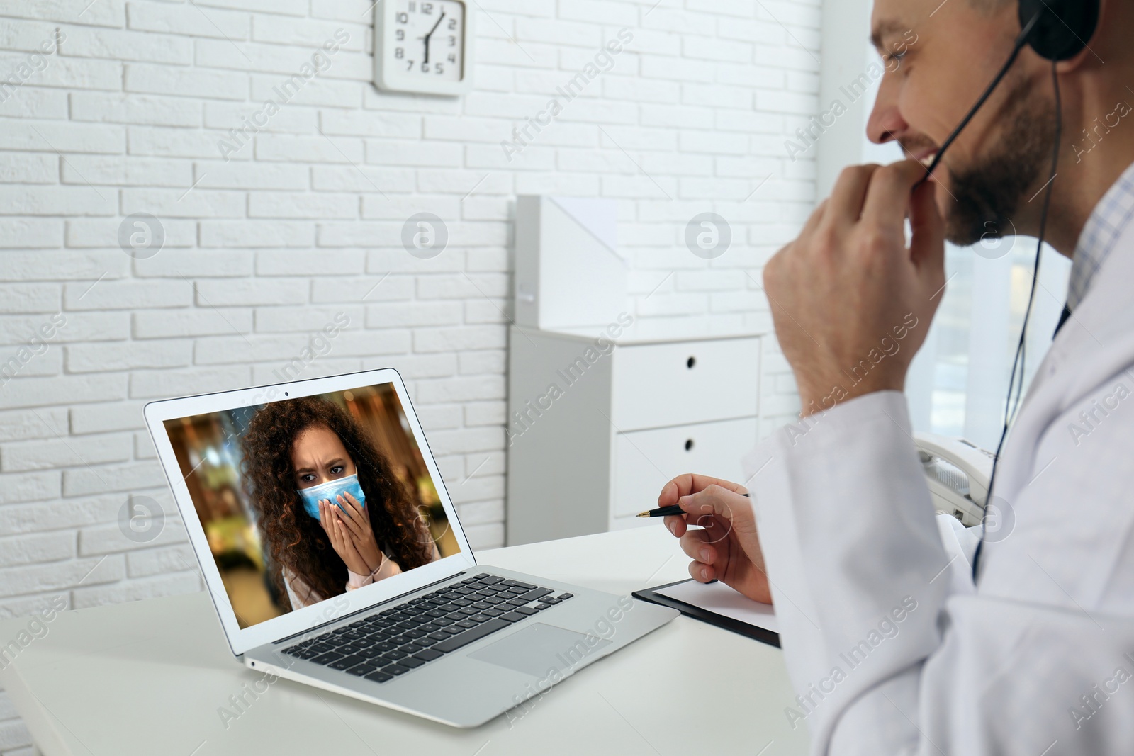 Image of Hotline service. Doctor consulting patient online via laptop indoors