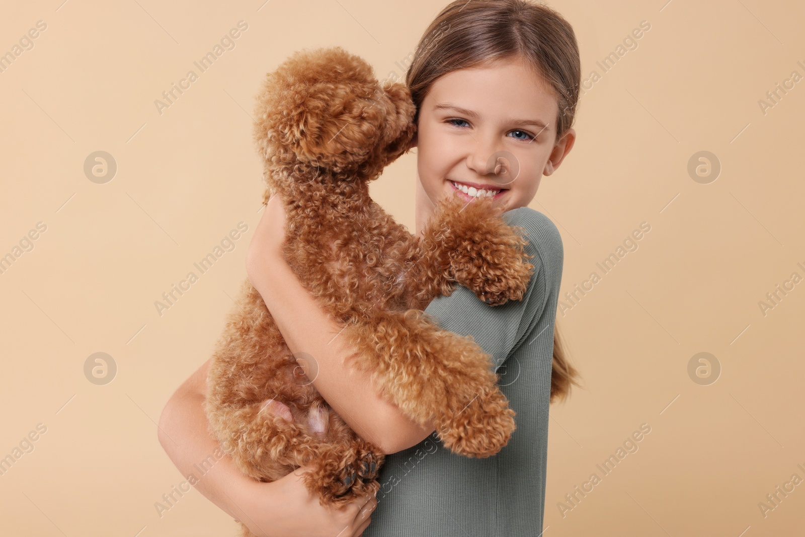 Photo of Little child with cute puppy on beige background. Lovely pet