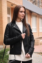 Beautiful young woman wearing stylish autumn clothes on city street