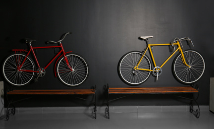 Color bicycles hanging on black wall indoors