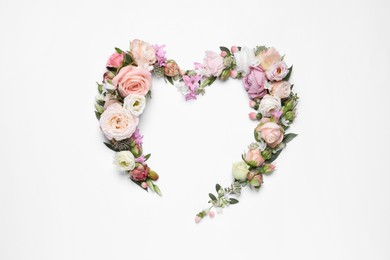 Photo of Beautiful heart made of different flowers on white background, top view