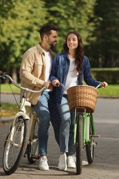 Photo of Beautiful couple with bicycles spending time together in park