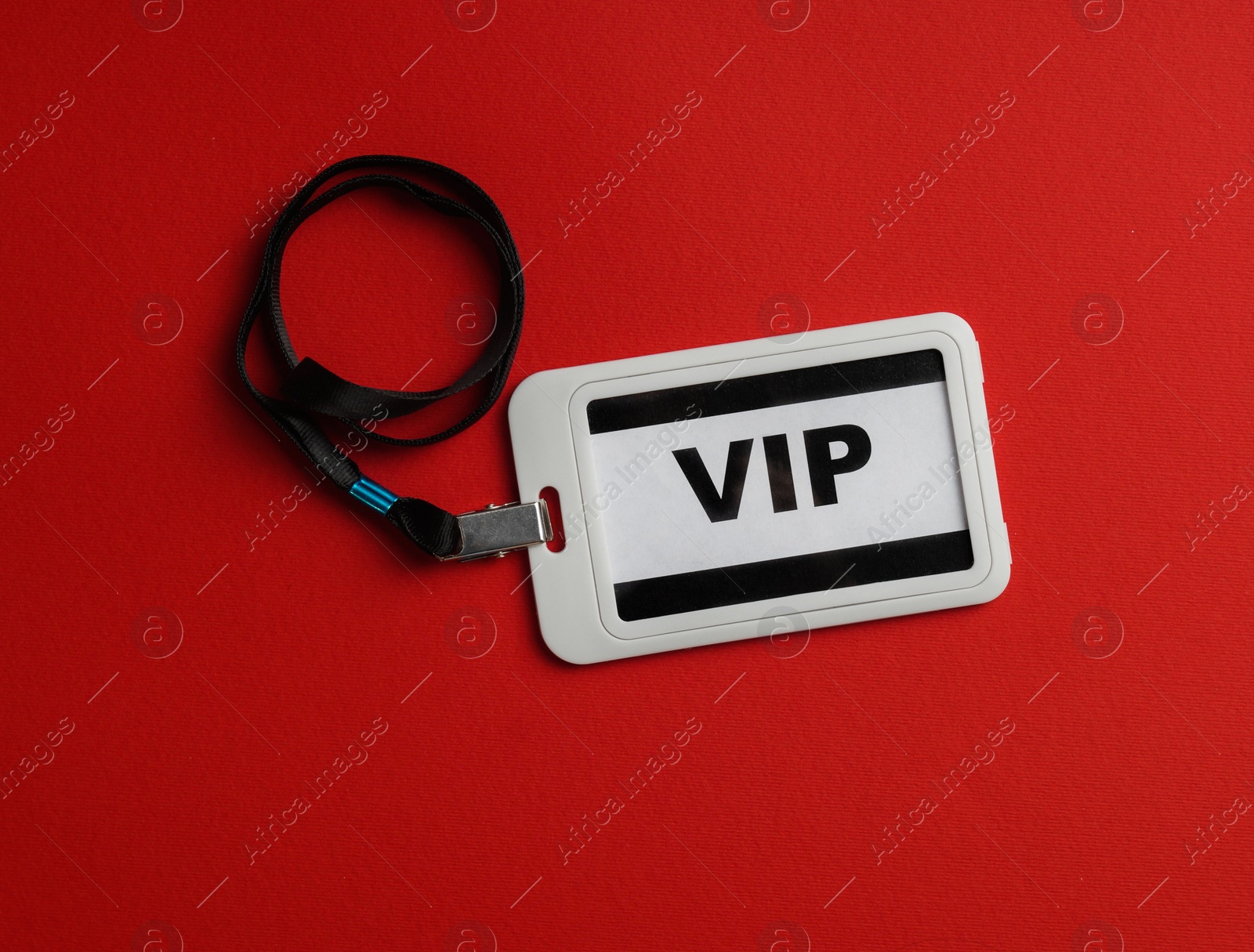 Photo of Plastic vip badge on red background, top view