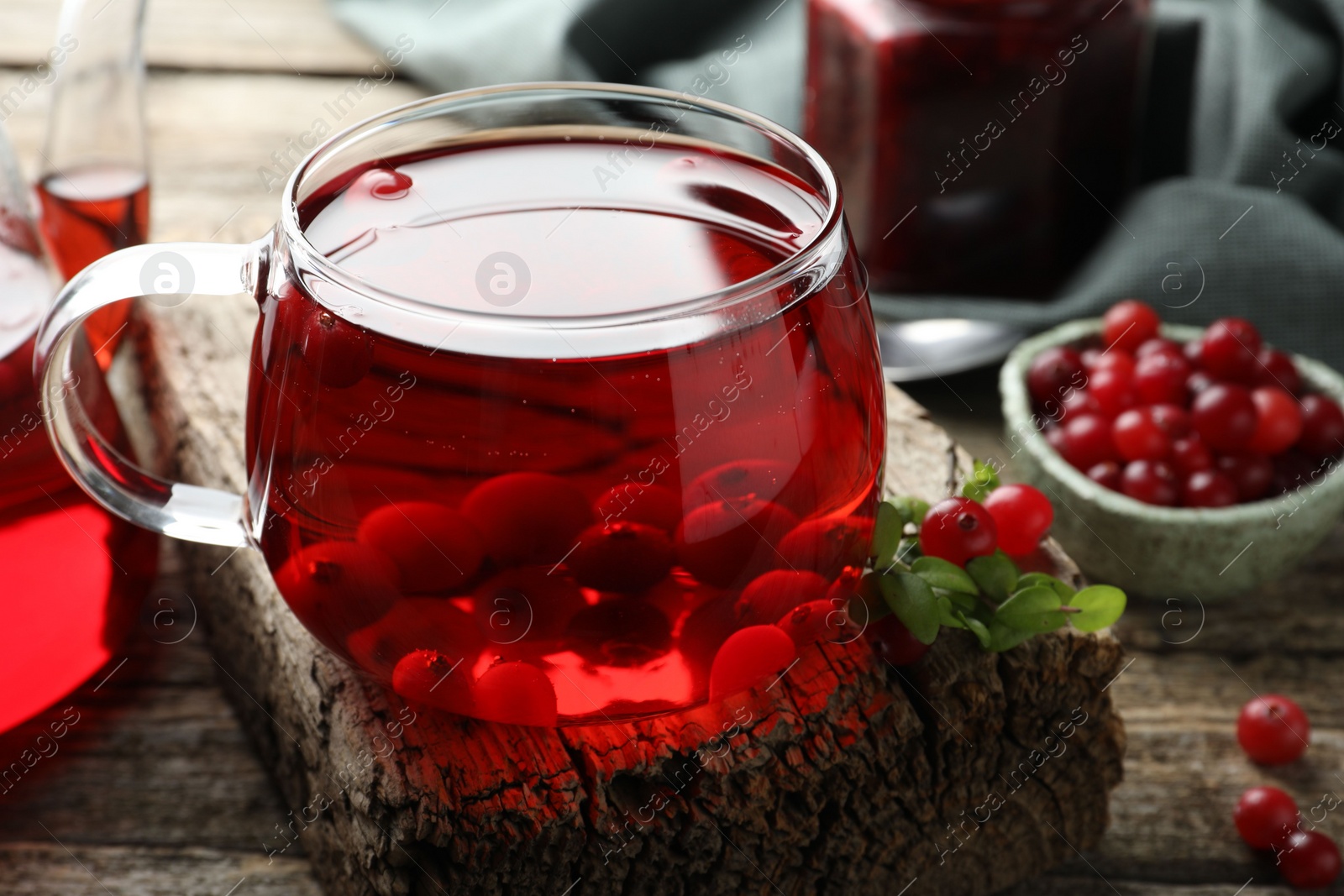 Photo of Delicious cranberry tea and berries on wooden table, closeup