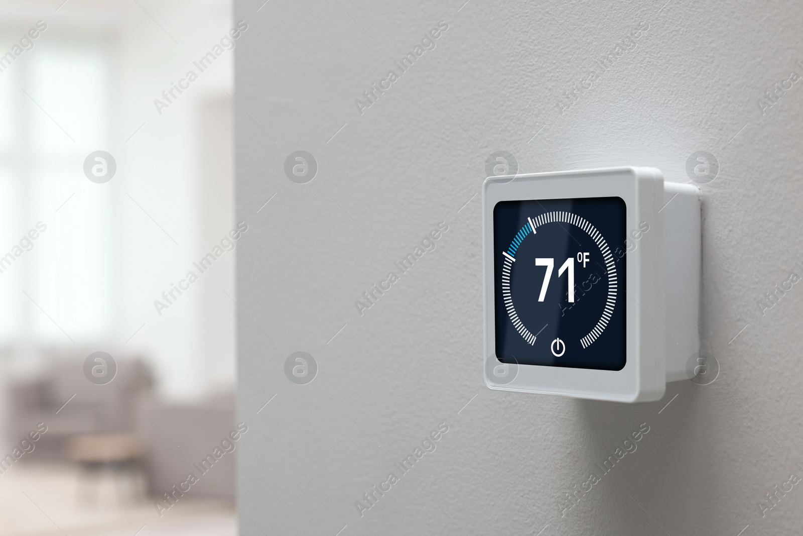 Image of Thermostat displaying temperature in Fahrenheit scale. Smart home device on white wall, space for text