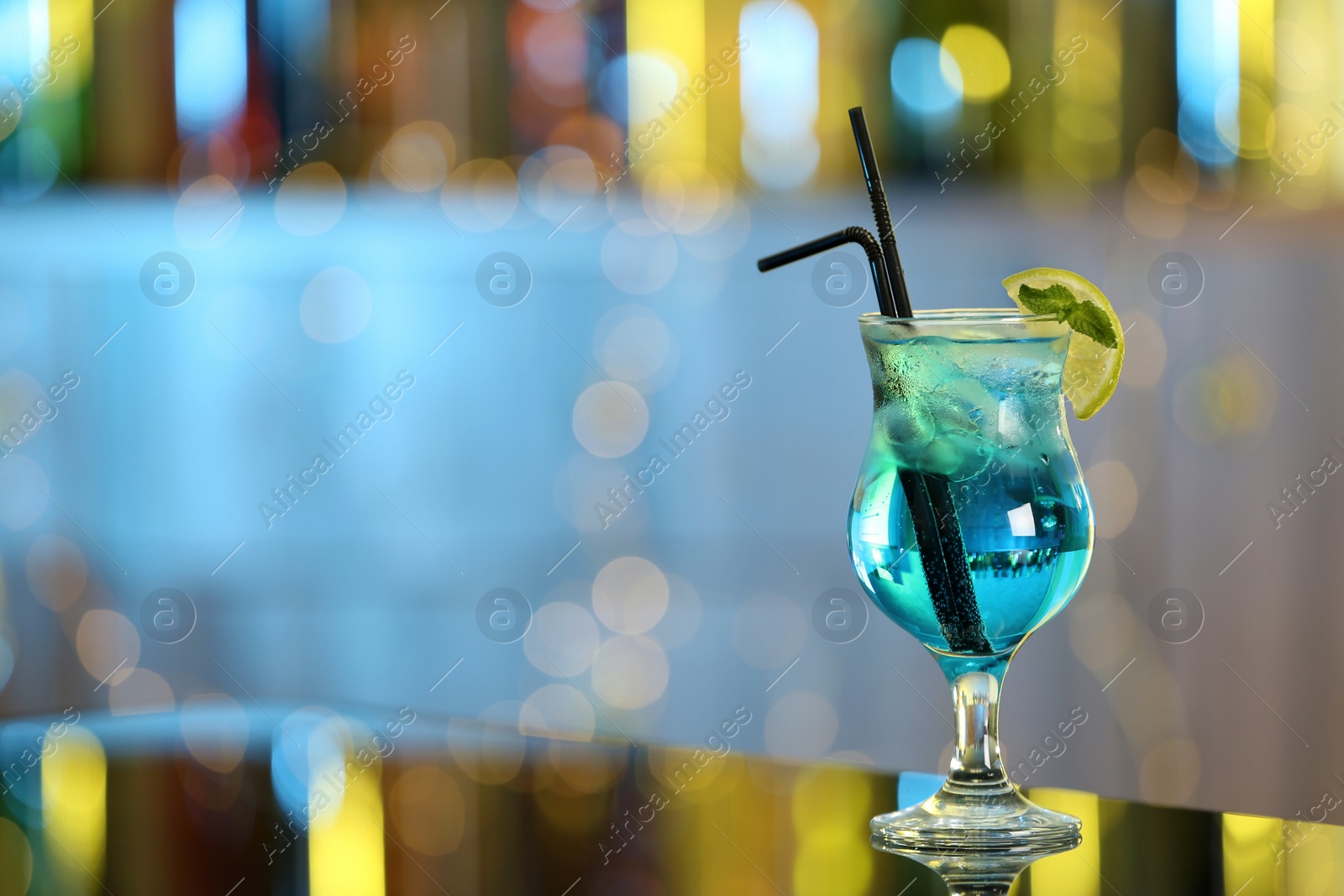 Photo of Glass of fresh alcoholic cocktail on bar counter. Space for text