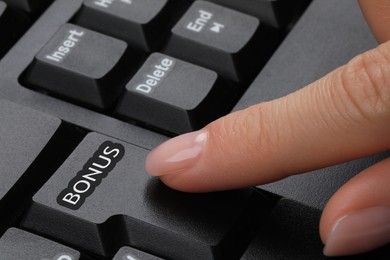 Image of Woman pressing Bonus button on keyboard, closeup