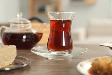 Cup of delicious Turkish tea served on wooden table, closeup