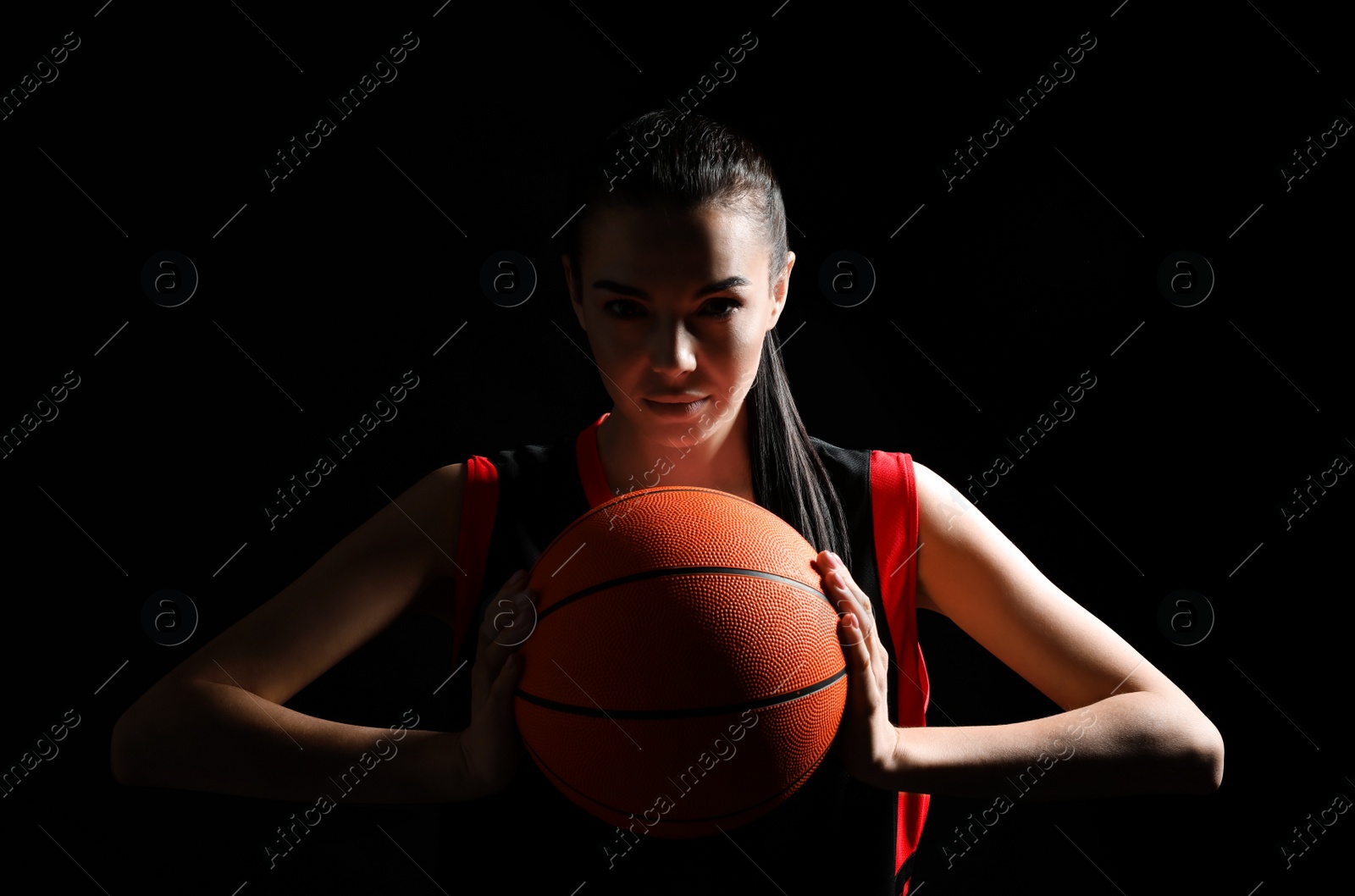 Photo of Basketball player with ball on black background