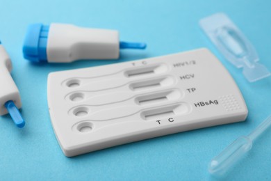 Photo of Disposable multi-infection express test kit on light blue background, closeup