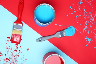 Flat lay composition with paint cans and brushes on color background