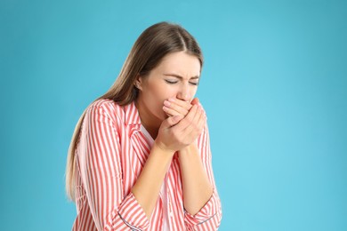 Woman suffering from nausea on light blue background, space for text. Food poisoning