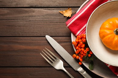 Photo of Top view of seasonal table setting with pumpkin and ashberries on wooden background, space for text. Thanksgiving Day